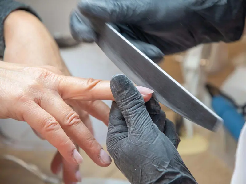 Nail technician filing and shaping nails during a manicure Beauty by Ana St Albans